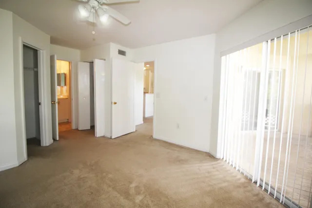 an empty room with windows and closet area
