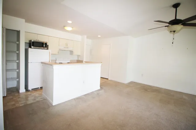 a kitchen with kitchen island white cabinets and refrigerator