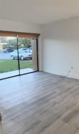 a view of a room with wooden floor and windows