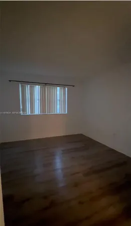 a view of wooden floor and a window in an empty room