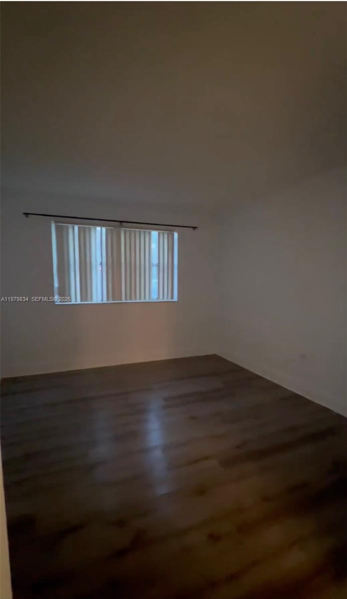 15640 Southwest 80th Street, Unit G103 Miami, FL 33193 - Photo 5 of 11 a view of wooden floor and a window in an empty room
