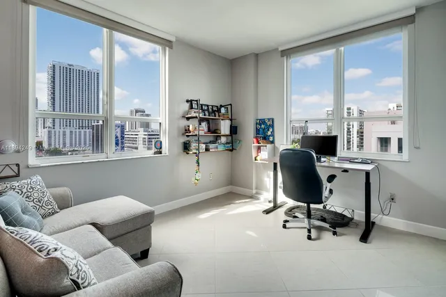 a view of a livingroom with workspace and a window
