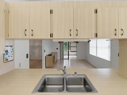 a kitchen with kitchen island granite countertop a sink and white cabinets