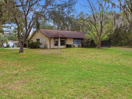 a front view of a house with a garden and trees