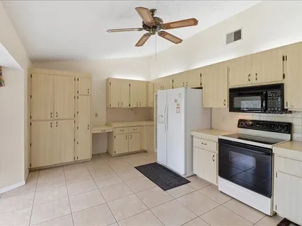 a kitchen with white cabinets and white appliances