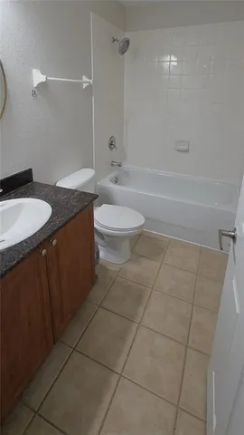 a bathroom with a granite countertop sink a toilet and shower