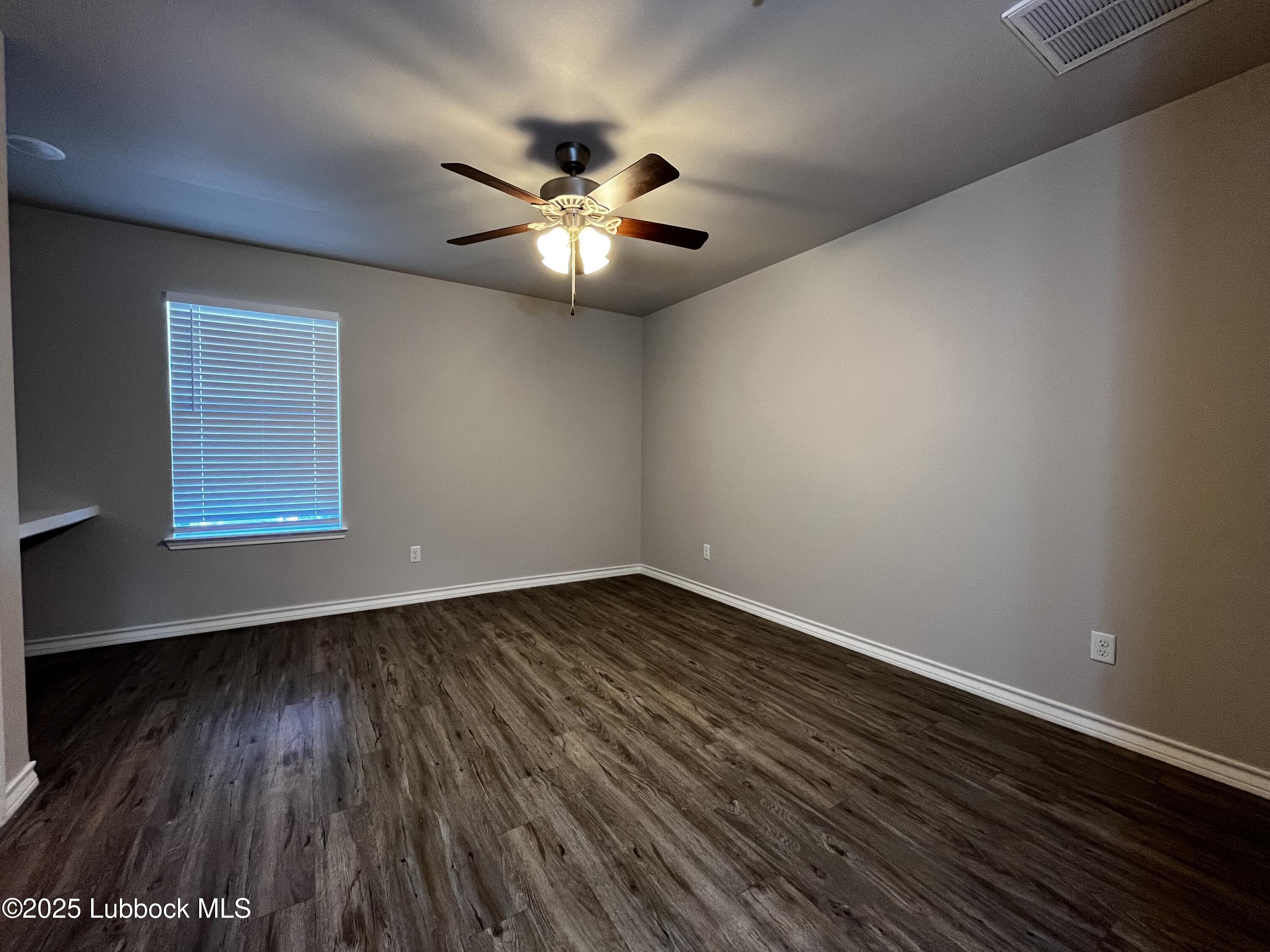 3404 25th Street, Unit 4 Lubbock, TX 79410 - Photo 15 of 15 a view of an empty room with wooden floor and a window