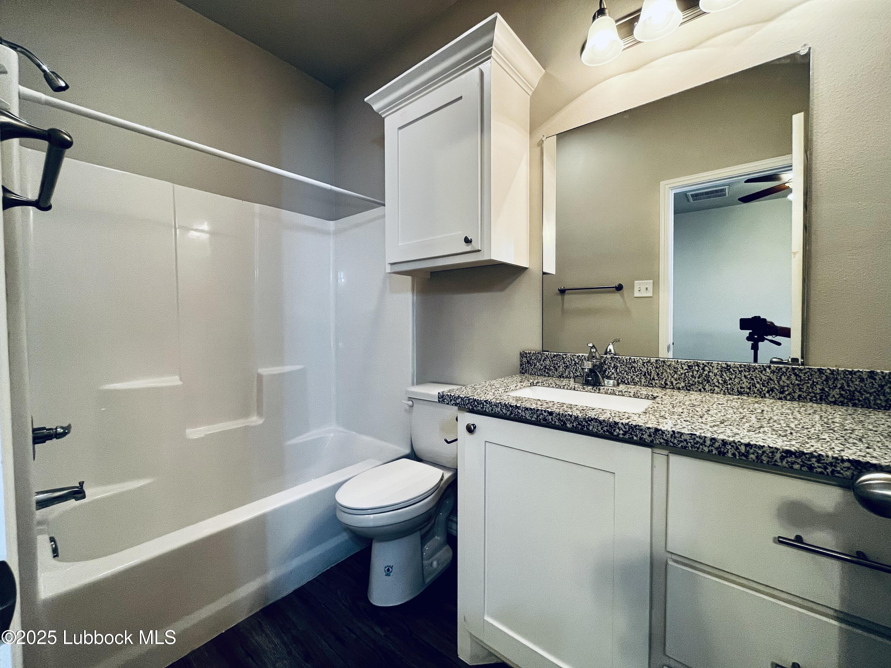 3404 25th Street, Unit 4 Lubbock, TX 79410 - Photo 8 of 15 a bathroom with a granite countertop sink toilet and shower