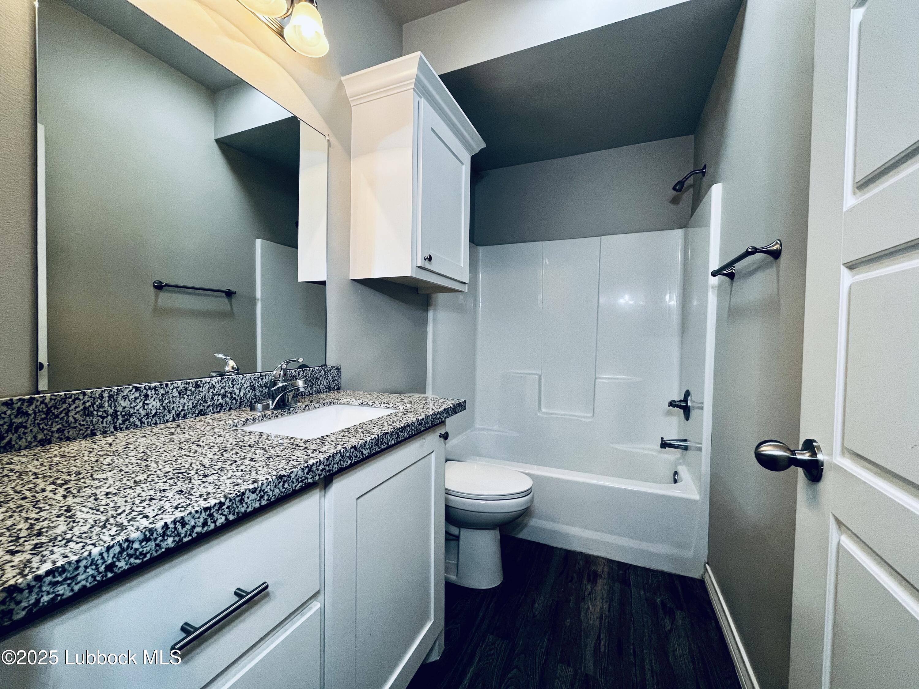 3404 25th Street, Unit 4 Lubbock, TX 79410 - Photo 9 of 15 a bathroom with a granite countertop sink toilet and shower