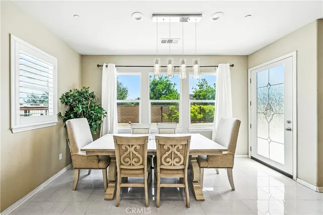 a dining room with furniture a chandelier and wooden floor