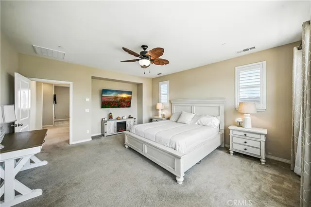a spacious bedroom with a bed and a chandelier
