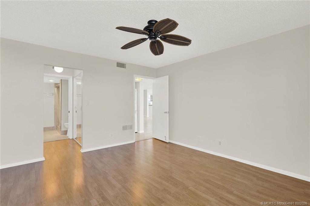 1950 Southwest Palm City Road, Unit 13301 Stuart, FL 34994 - Photo 29 of 58 a view of an empty room with wooden floor and a ceiling fan