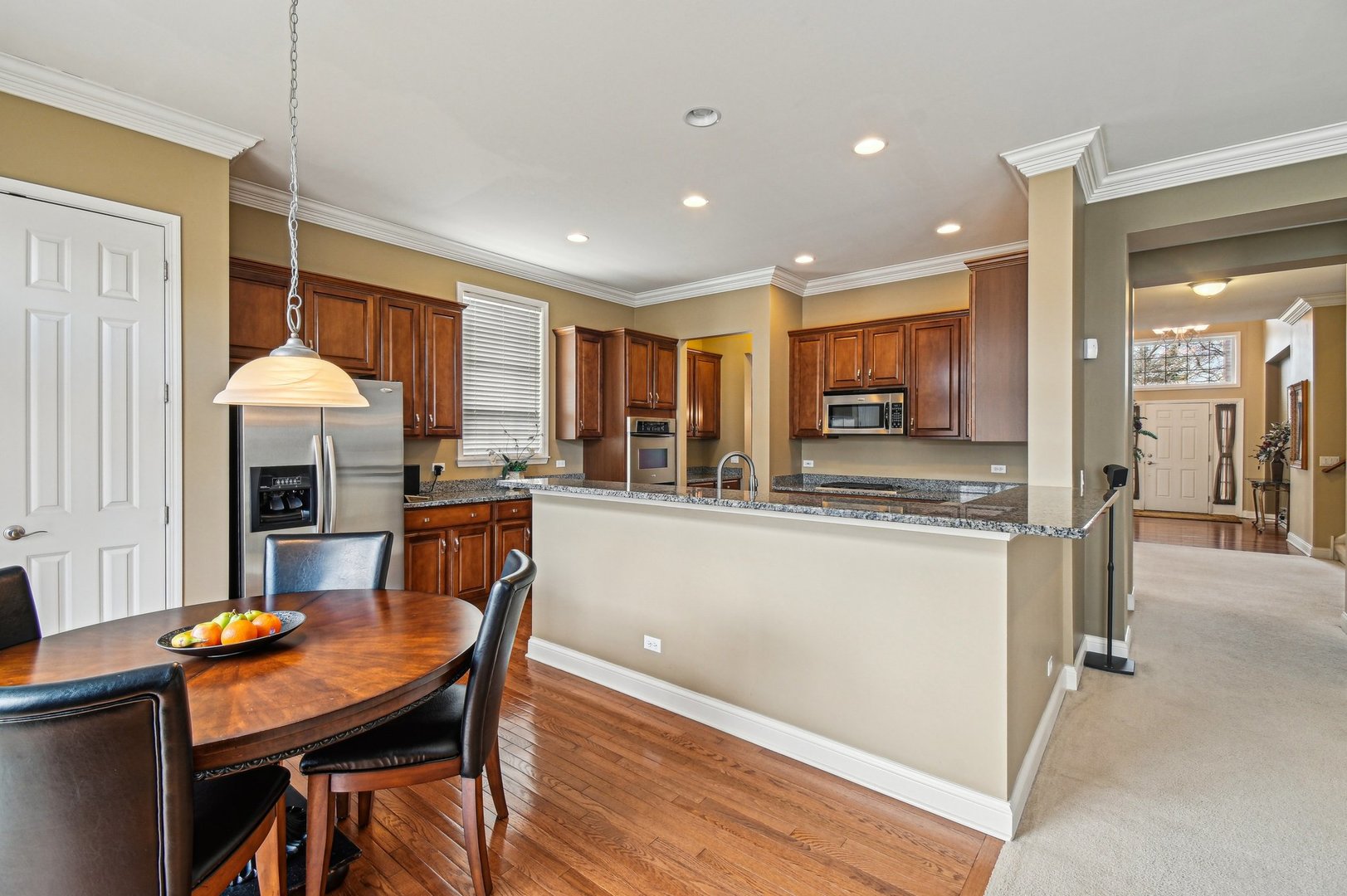 1037 Moray Drive Inverness, IL 60010 - Photo 16 of 50 a kitchen with a table chairs refrigerator and microwave