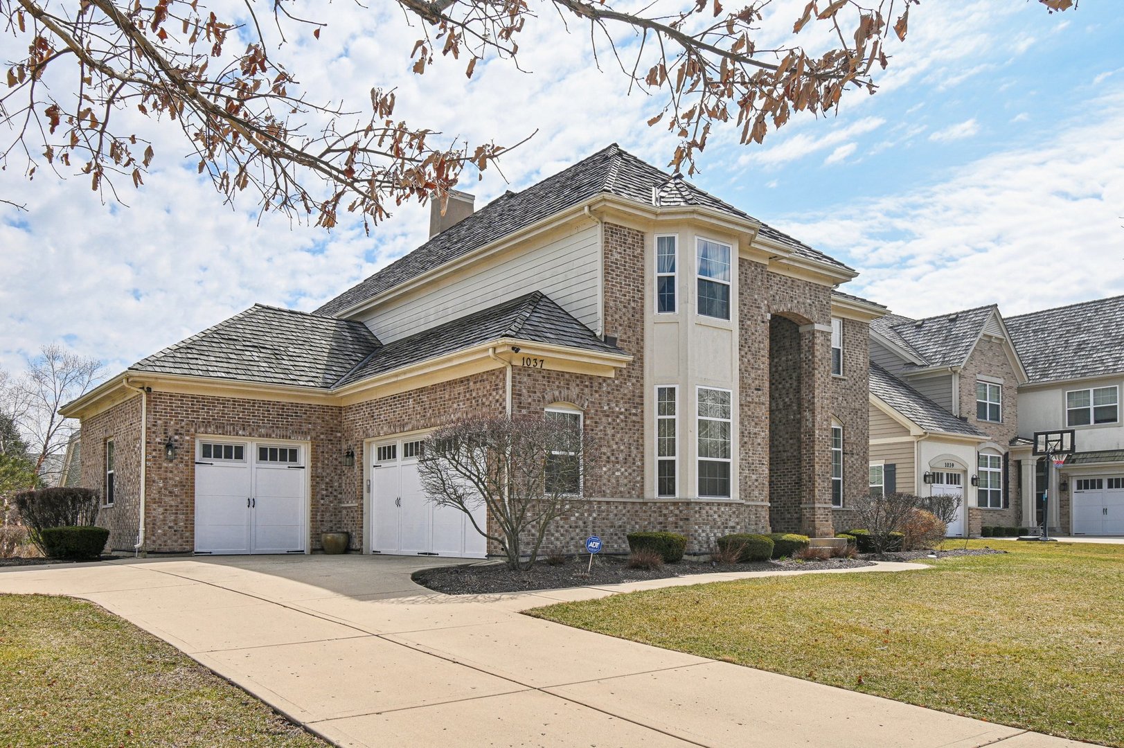 1037 Moray Drive Inverness, IL 60010 - Photo 47 of 50 a front view of a building with a garden and trees