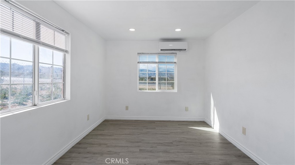 5827 Old Woman Springs Road Johnson Valley, CA 92285 - Photo 22 of 36 an empty room with wooden floor and windows