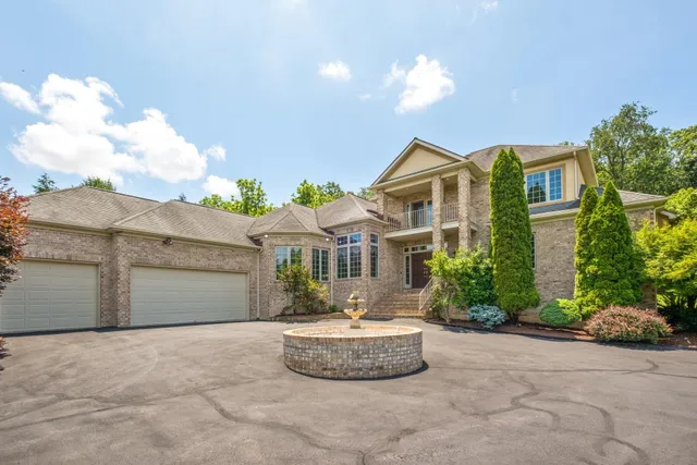 a front view of a house with a yard and potted plants