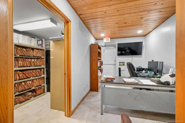 a view of workspace with wooden floor and flat screen tv