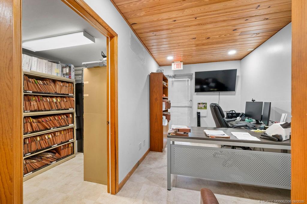 400 Southeast Flamingo Avenue Stuart, FL 34996 - Photo 13 of 33 a view of workspace with wooden floor and flat screen tv