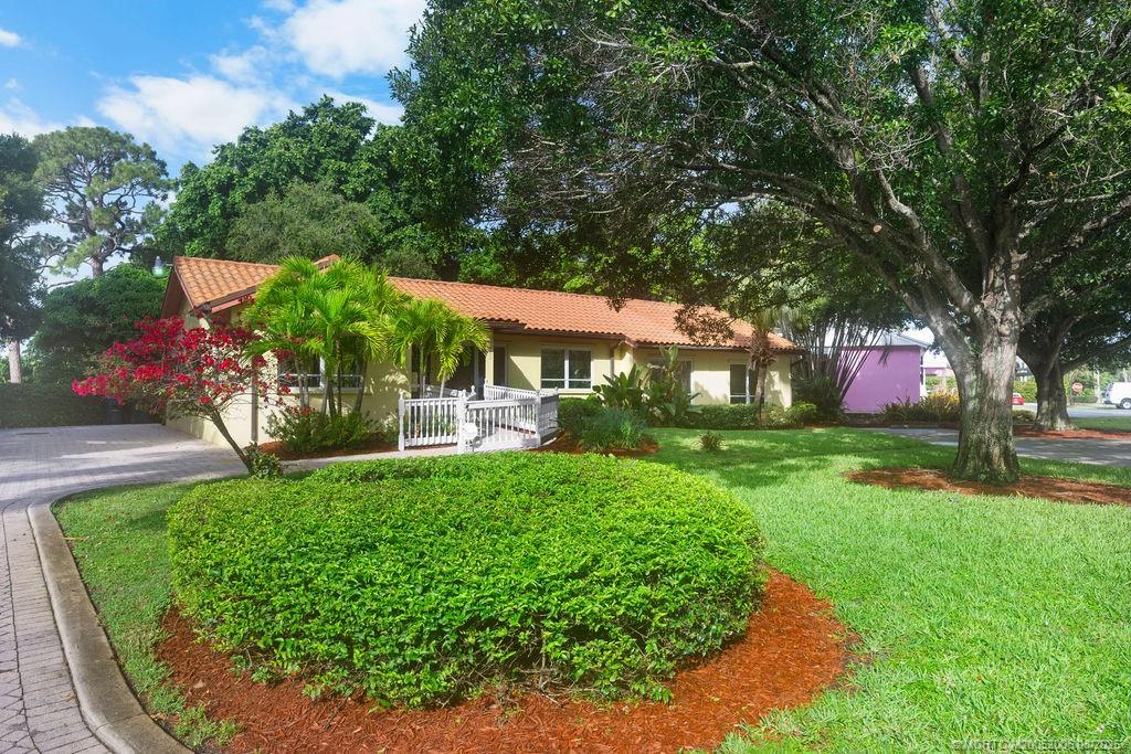 400 Southeast Flamingo Avenue Stuart, FL 34996 - Photo 17 of 33 a view of a patio with table and chairs under an umbrella