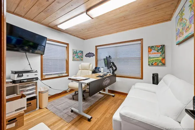 a living room with furniture a flat screen tv and kitchen view