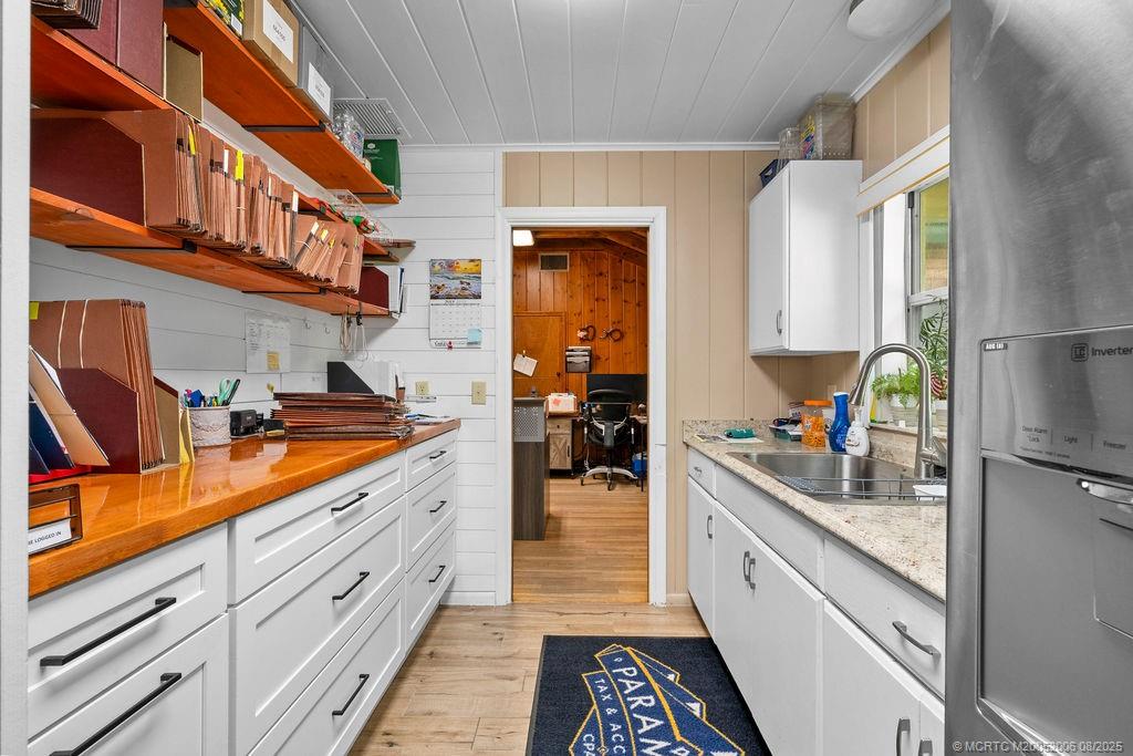 400 Southeast Flamingo Avenue Stuart, FL 34996 - Photo 7 of 33 a kitchen with stainless steel appliances granite countertop a sink and cabinets