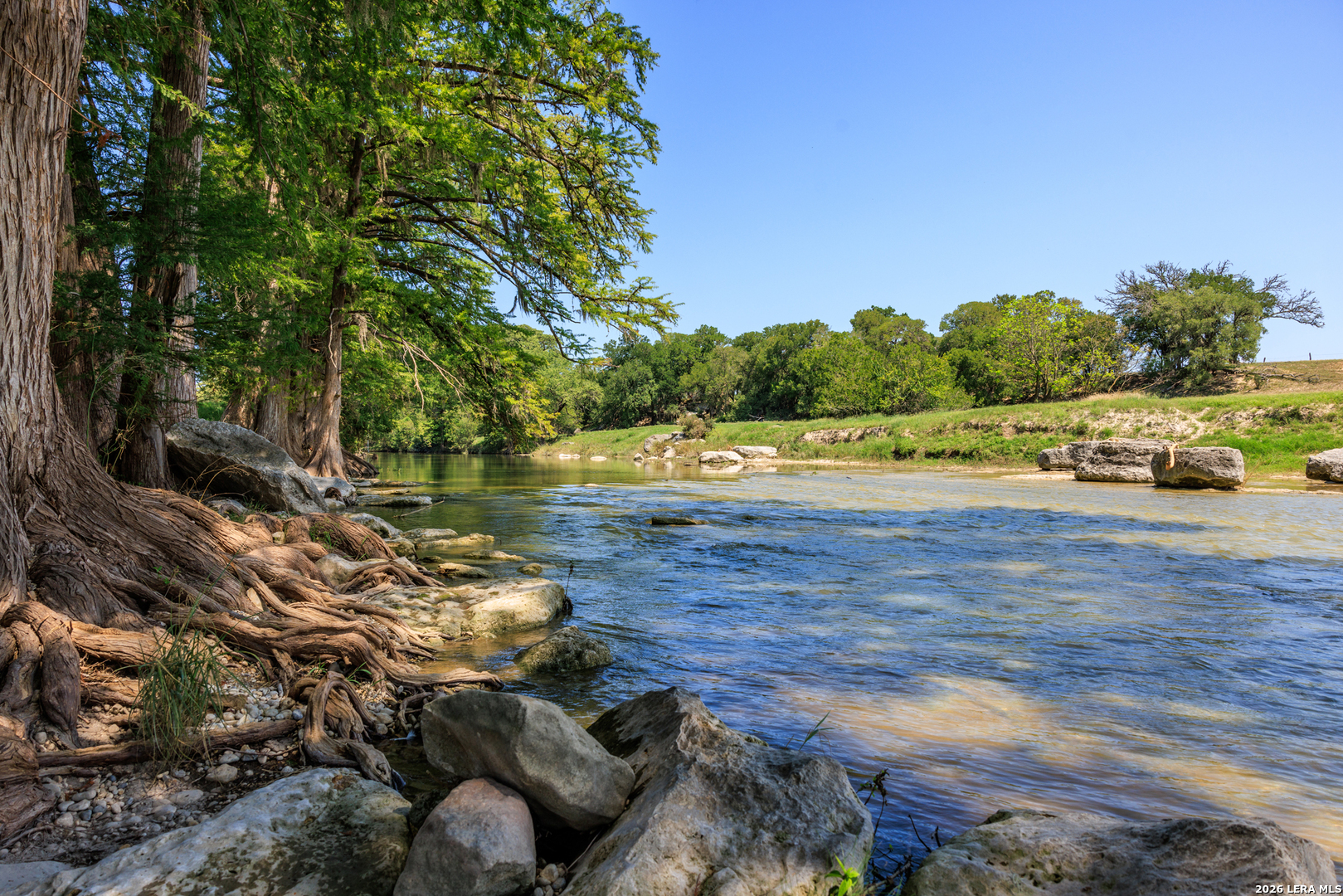 0 Comfort River Ranch Comfort, TX 78013 - Photo 13 of 23 a view of a lake with lawn chairs and large trees