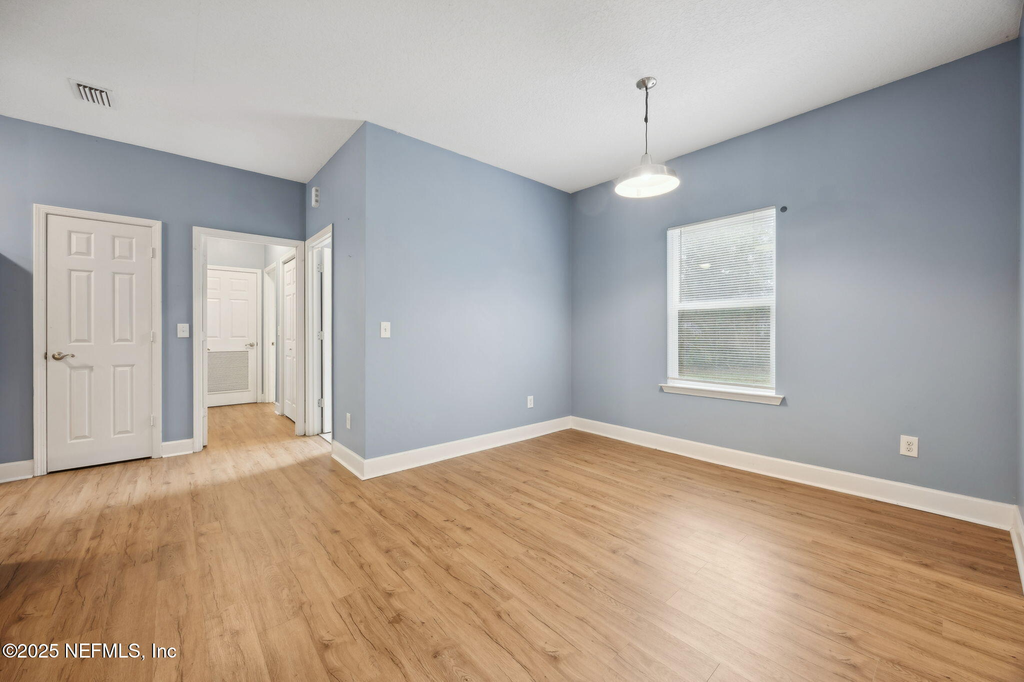 85484 Miner Road Yulee, FL 32097 - Photo 11 of 38 an empty room with wooden floor and windows