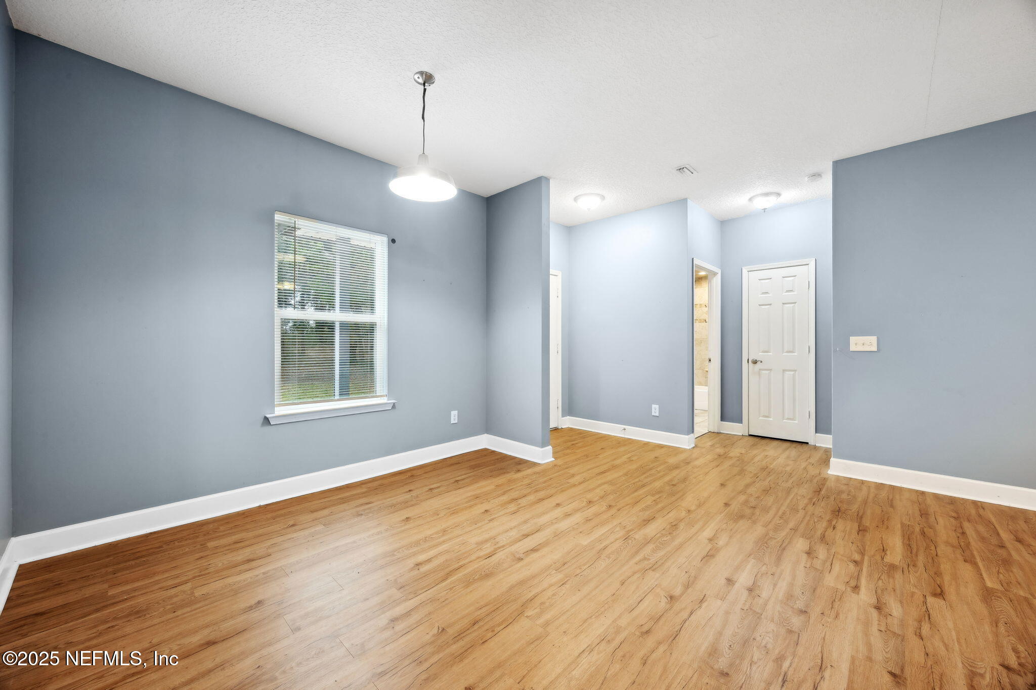 85484 Miner Road Yulee, FL 32097 - Photo 12 of 38 a view of an empty room with wooden floor and a window