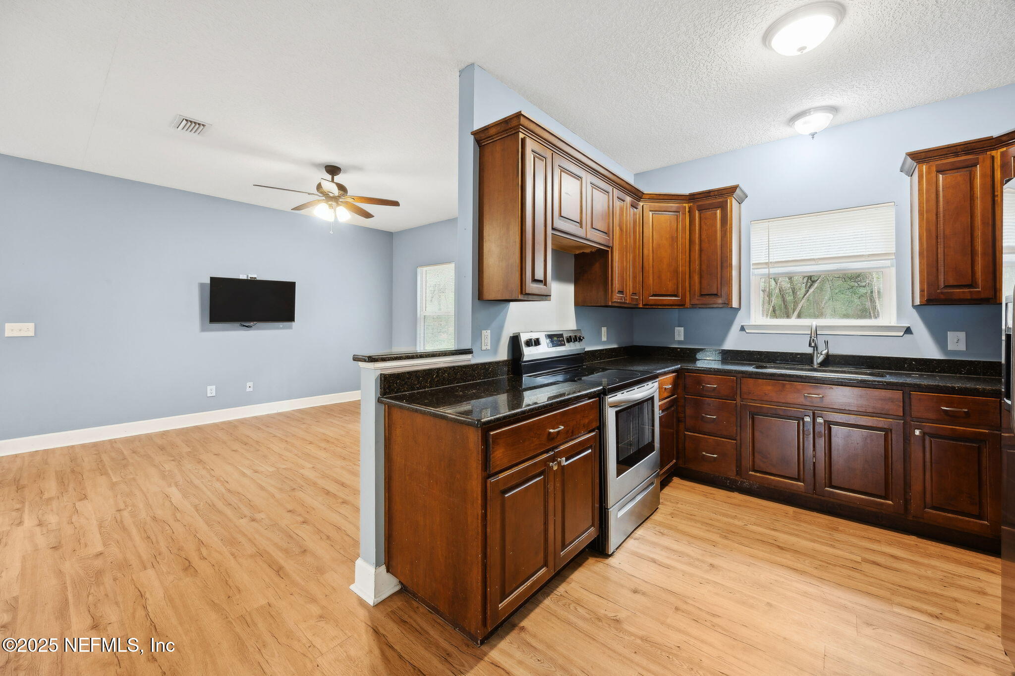 85484 Miner Road Yulee, FL 32097 - Photo 16 of 38 a kitchen with stainless steel appliances granite countertop a stove a sink and a microwave
