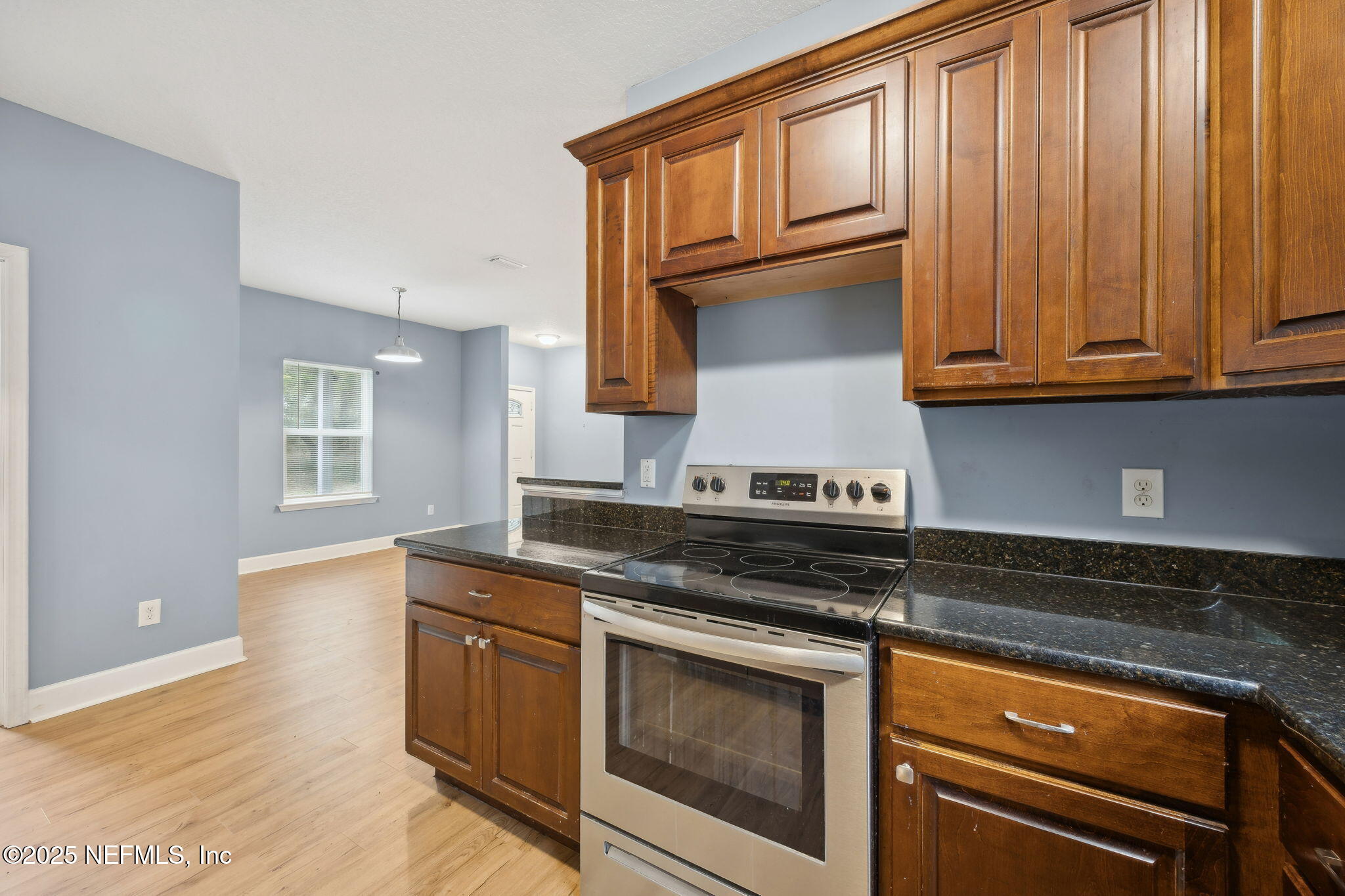 85484 Miner Road Yulee, FL 32097 - Photo 19 of 38 a kitchen with granite countertop wooden cabinets stainless steel appliances and a sink