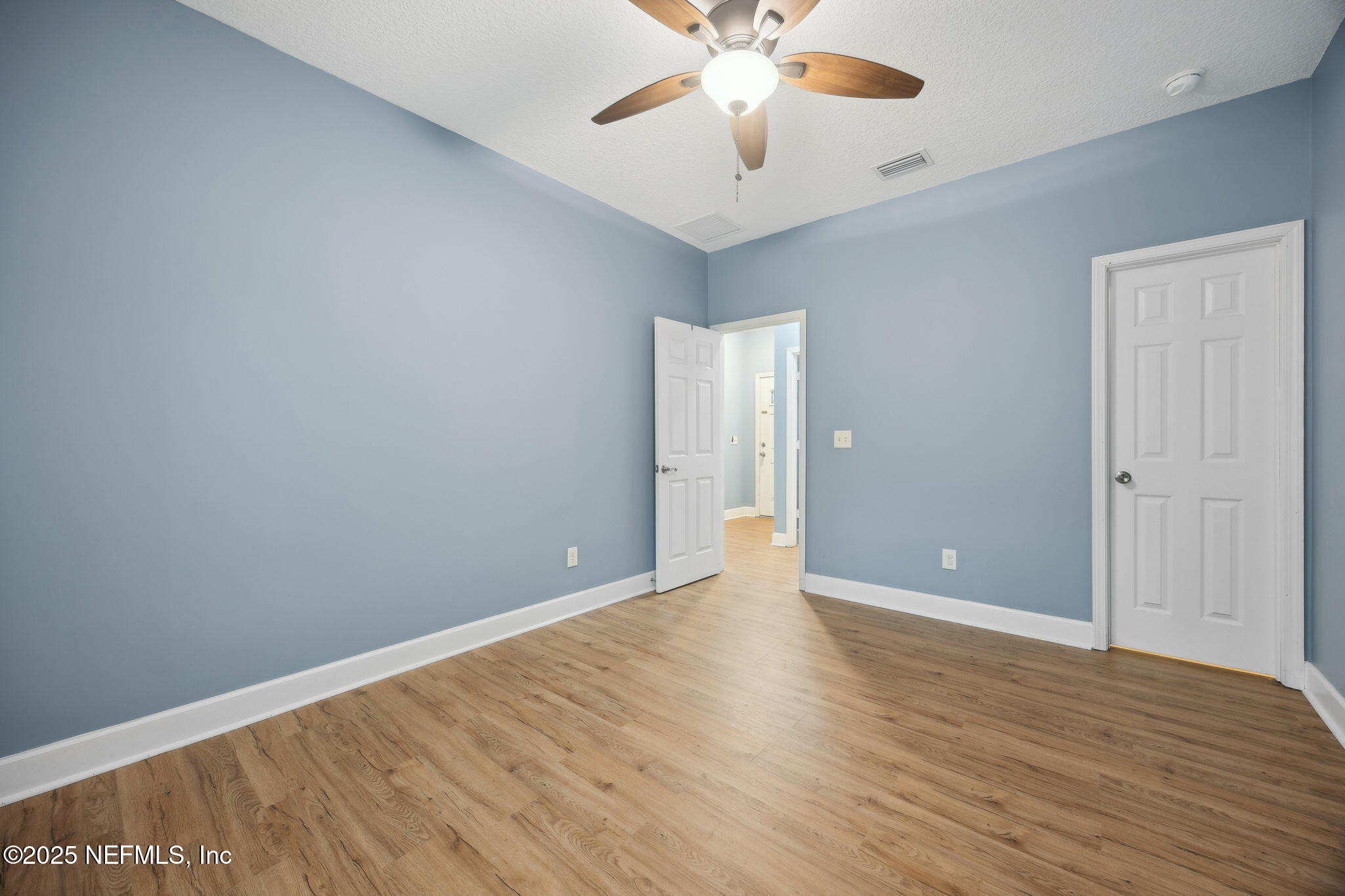 85484 Miner Road Yulee, FL 32097 - Photo 28 of 38 an empty room with wooden floor and fan