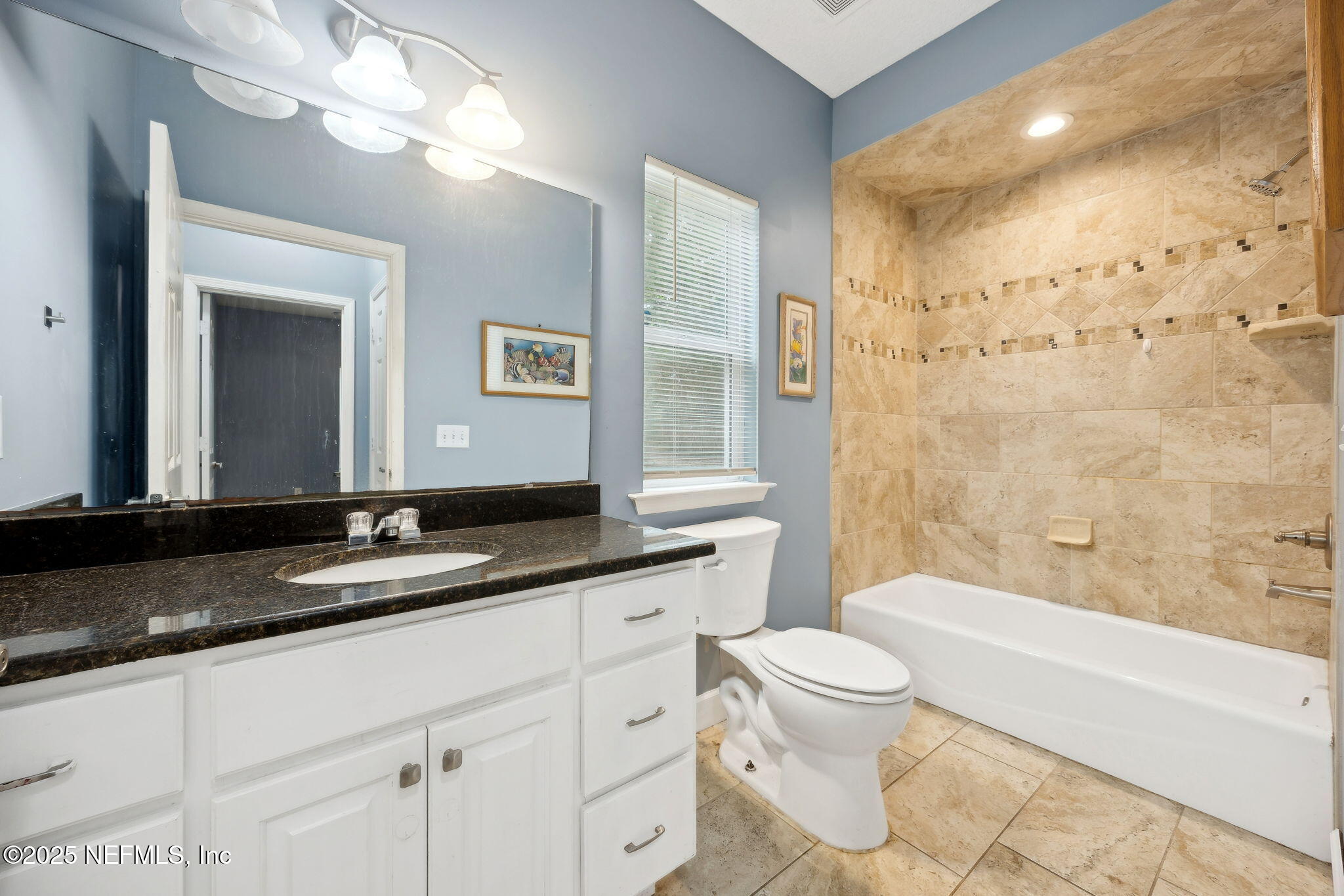 85484 Miner Road Yulee, FL 32097 - Photo 29 of 38 a bathroom with a granite countertop sink a toilet a mirror a bathtub and shower