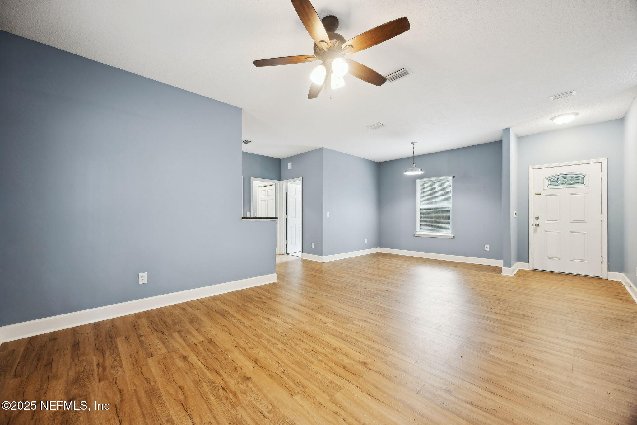 85484 Miner Road Yulee, FL 32097 - Photo 9 of 38 a view of empty room with wooden floor and fan