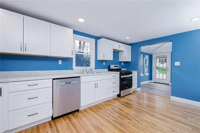 a kitchen with granite countertop white cabinets and white appliances