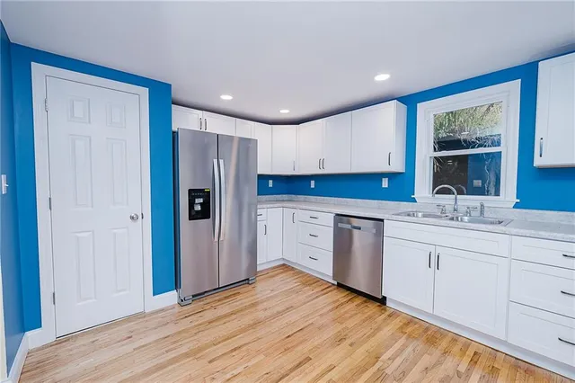 a kitchen with a refrigerator sink and cabinets