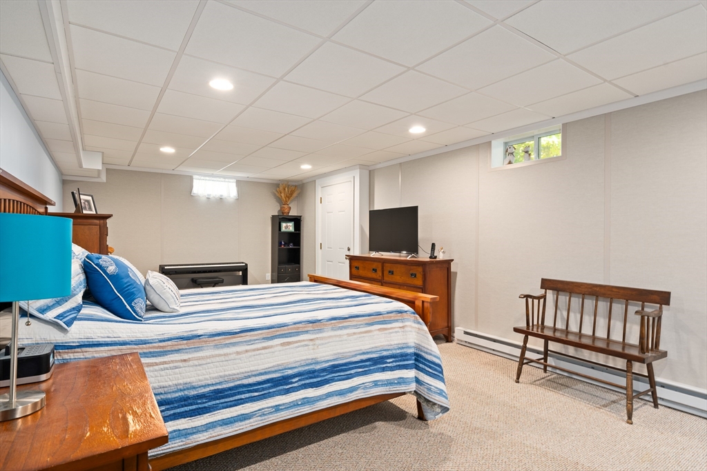 25 Paul Street Easthampton, MA 01027 - Photo 40 of 42 a bedroom with a bed a flat screen tv and paintings on the wall