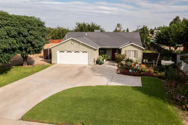 a front view of a house with a garden and yard