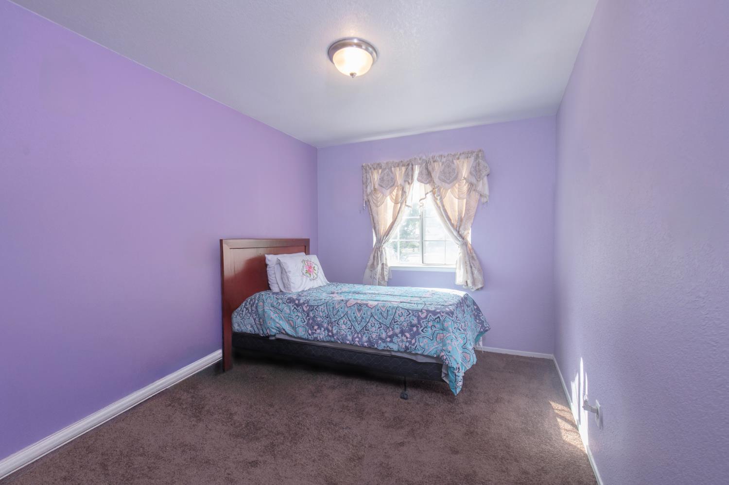 728 9th Street Sanger, CA 93657 - Photo 11 of 24 a bedroom with a bed and a window