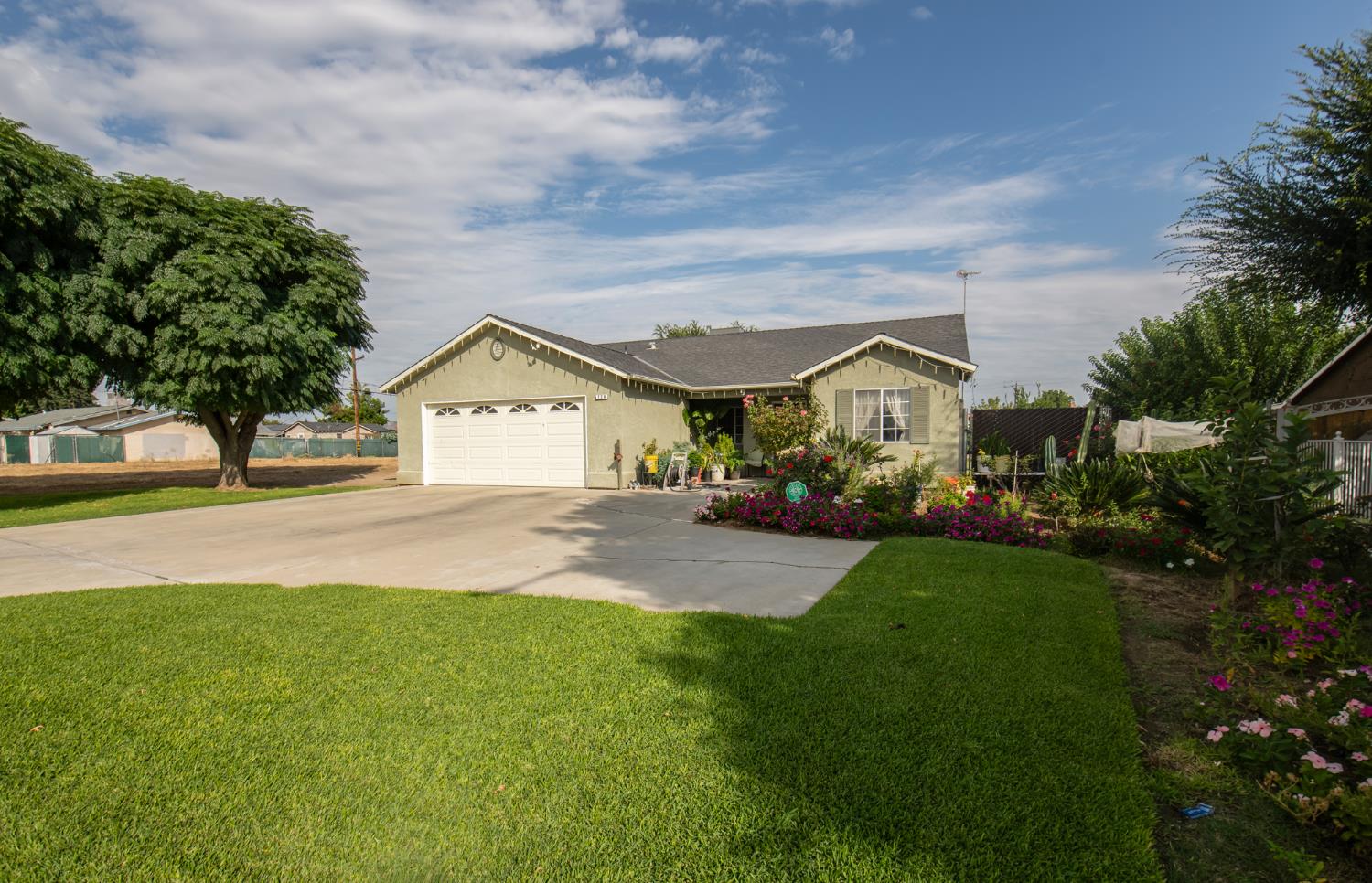 728 9th Street Sanger, CA 93657 - Photo 2 of 24 a view of house with garden and tall trees