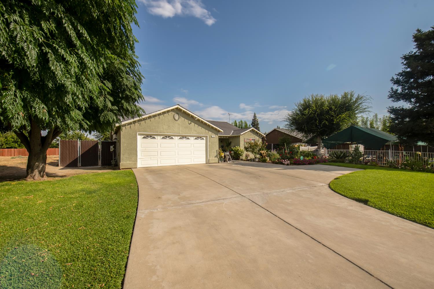 728 9th Street Sanger, CA 93657 - Photo 3 of 24 a front view of a house with a yard and garage
