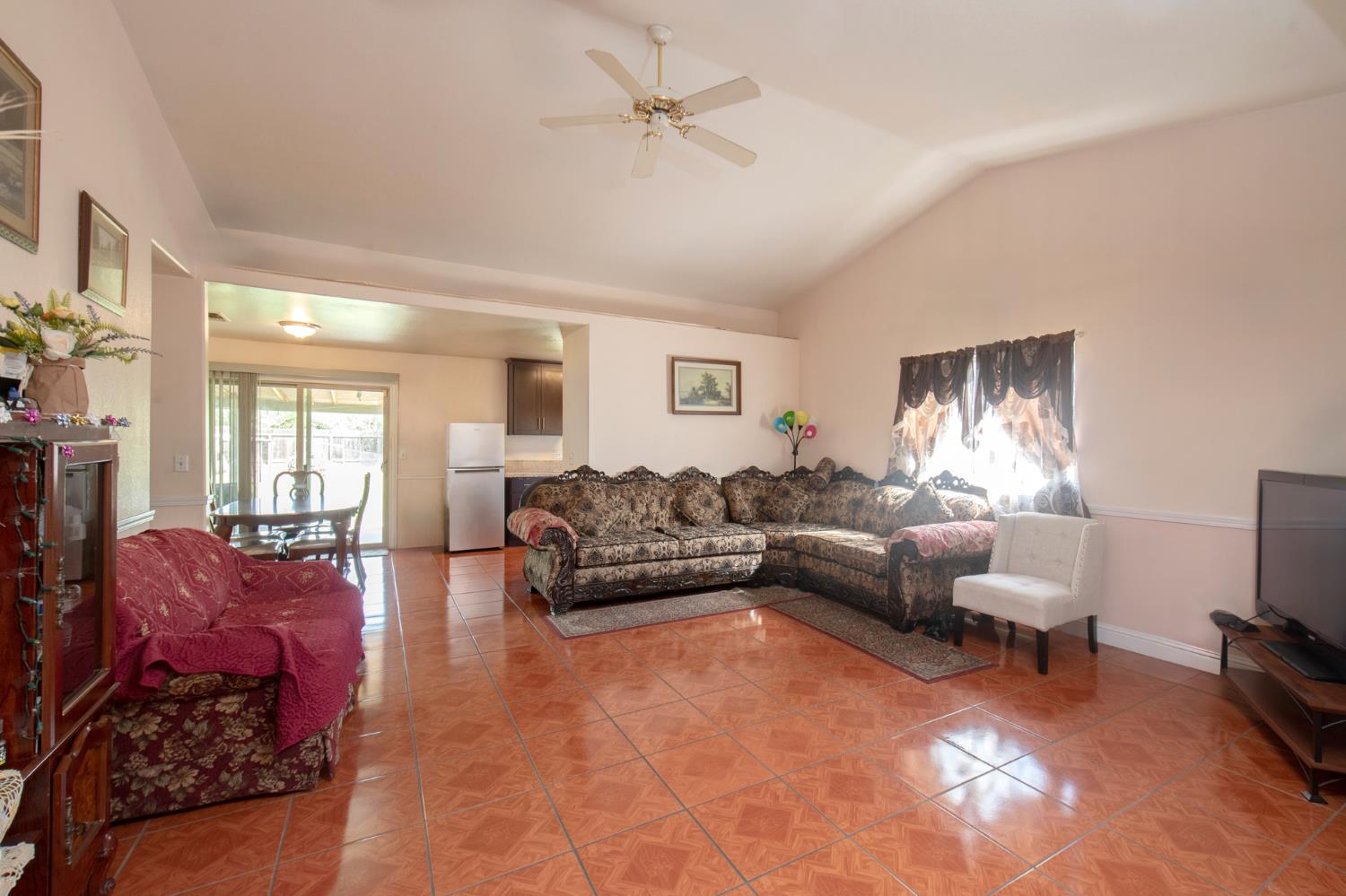 728 9th Street Sanger, CA 93657 - Photo 10 of 24 a living room with furniture a ceiling fan and a window