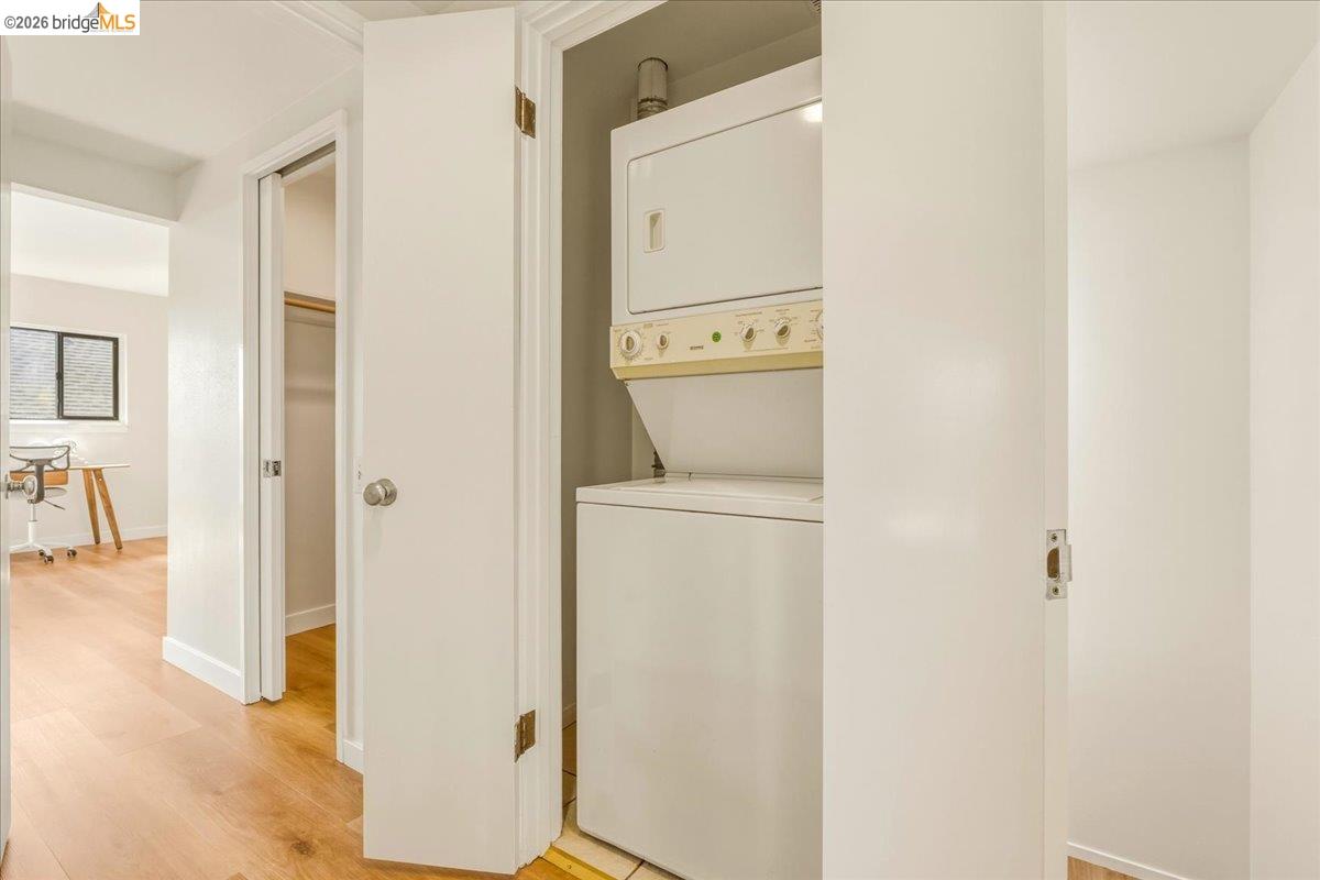 1408 Henry Street Berkeley, CA 94709 - Photo 19 of 28 Laundry area featuring stacked washer and clothes dryer and light wood finished floors