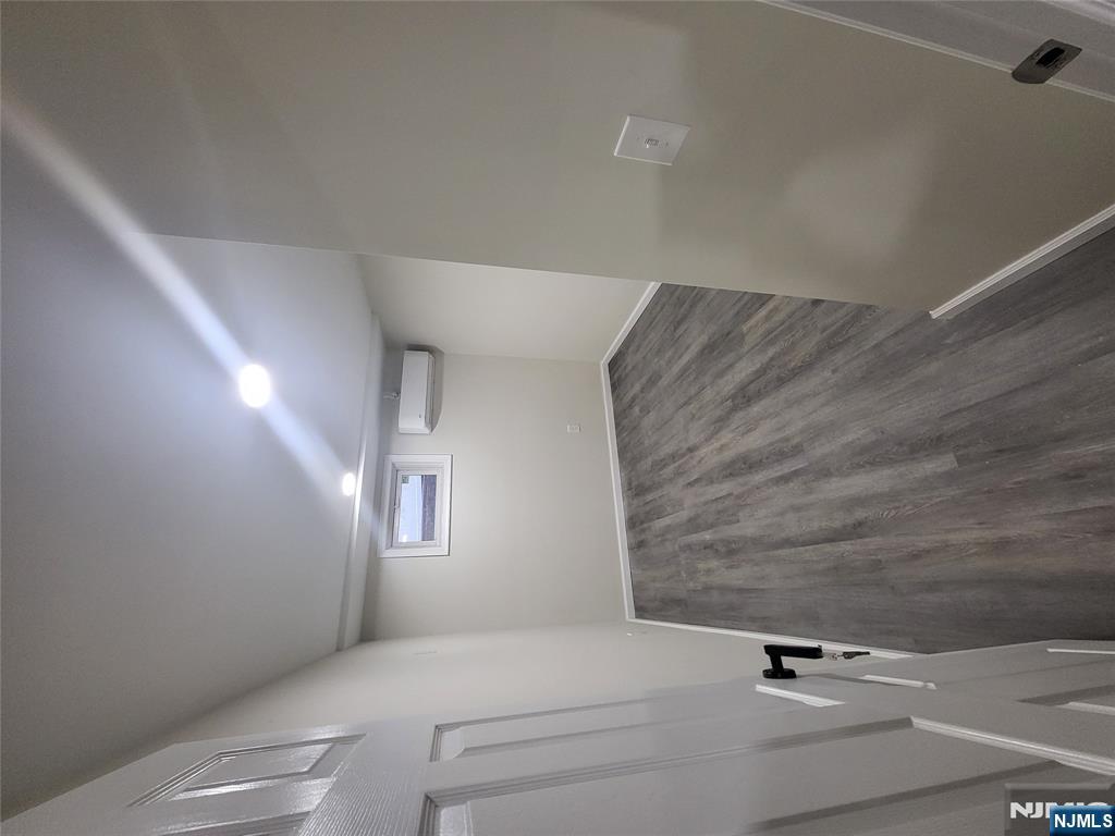 457 Elm Street Stirling, NJ 07980 - Photo 22 of 25 an empty room with wooden floor and white walls