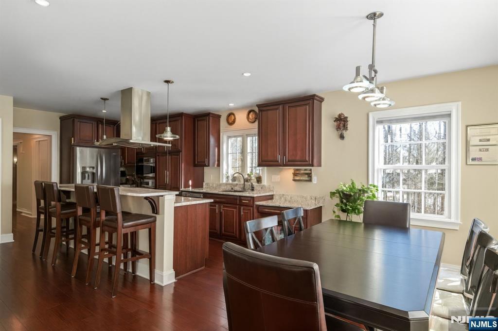 457 Elm Street Stirling, NJ 07980 - Photo 7 of 25 a kitchen with a dining table chairs stainless steel appliances and cabinets