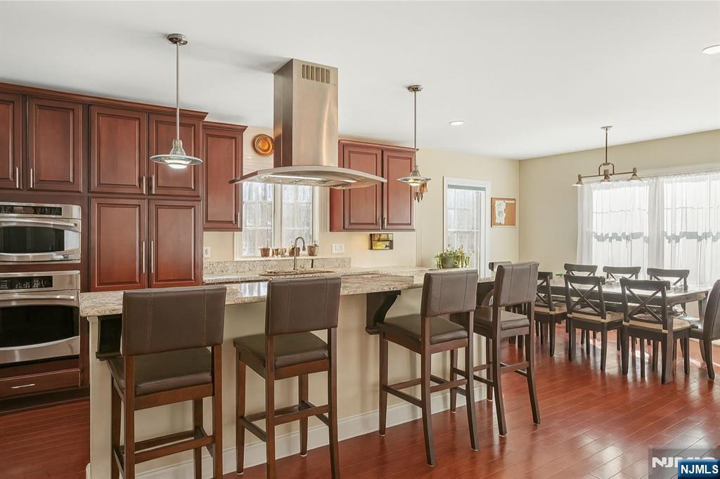 457 Elm Street Stirling, NJ 07980 - Photo 8 of 25 a kitchen with stainless steel appliances a dining table chairs and granite counter tops