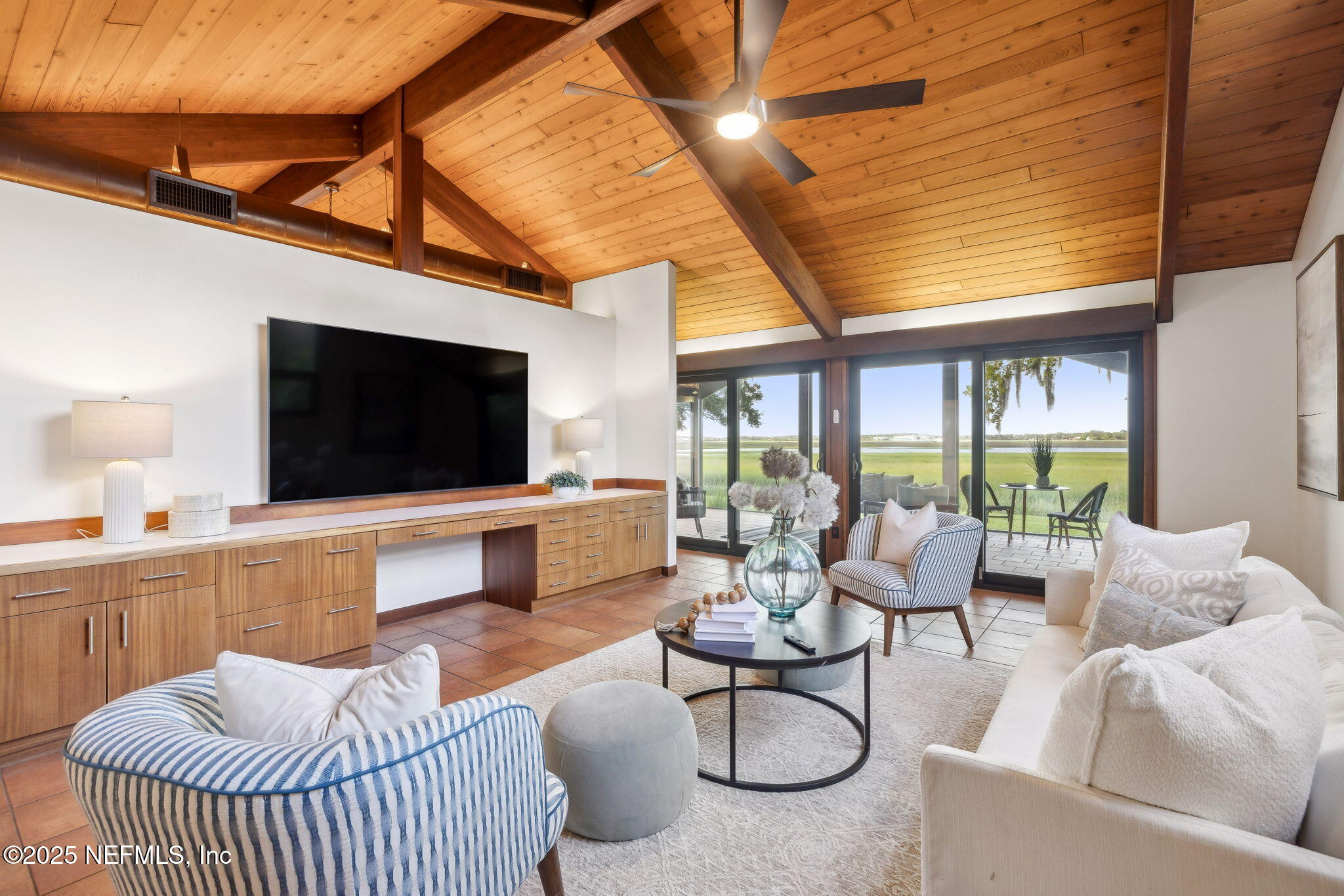 83 Tallwood Road Jacksonville Beach, FL 32250 - Photo 15 of 66 a living room with furniture a flat screen tv and a floor to ceiling window
