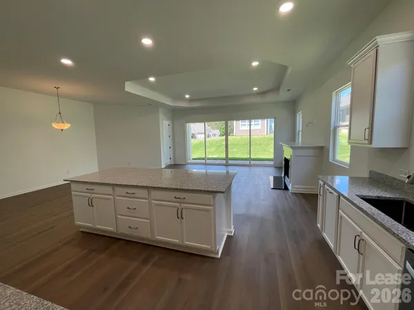 a large kitchen with stainless steel appliances a large counter top a stove and a wooden floors