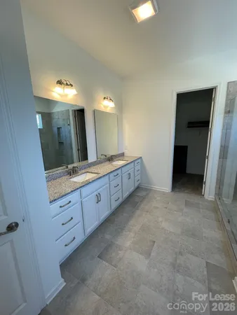 a bathroom with a double vanity sink and a mirror