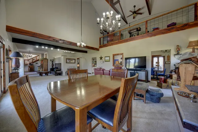 a dining room with furniture a chandelier and window