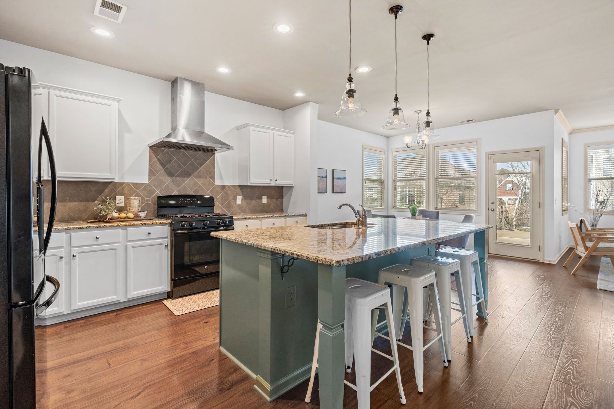 a kitchen with kitchen island granite countertop a sink a center island and stainless steel appliances